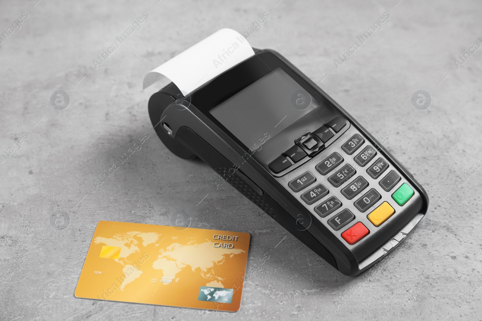 Photo of Modern payment terminal and credit card on grey background