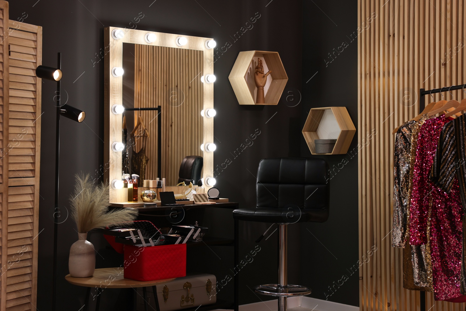Photo of Makeup room. Stylish mirror near dressing table with beauty products and chair indoors