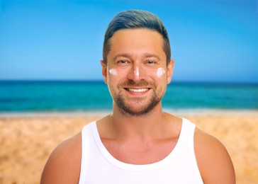 Image of Sun protection. Man with sunblock on his face near sea