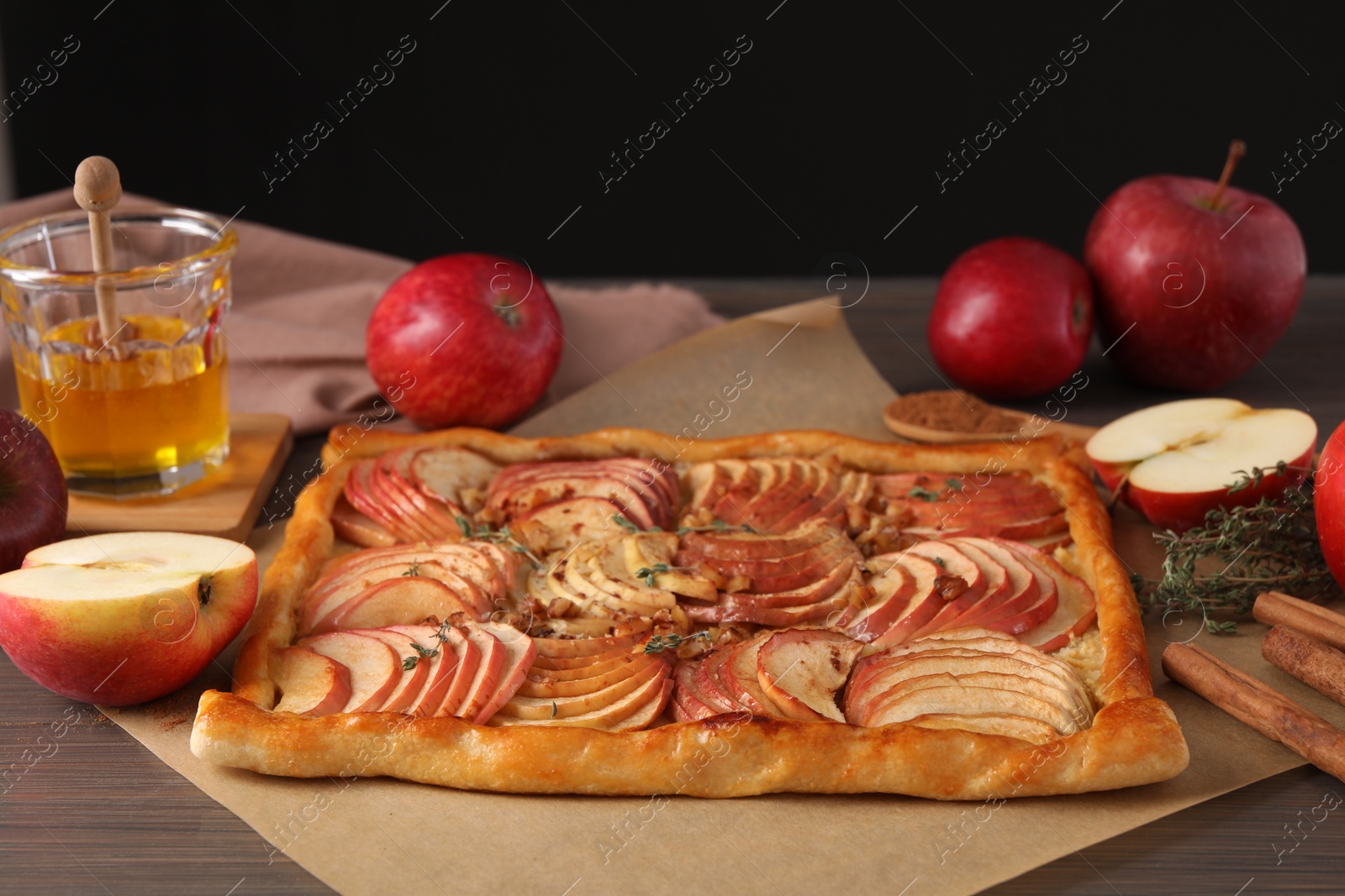 Photo of Freshly baked apple pie and ingredients on wooden table