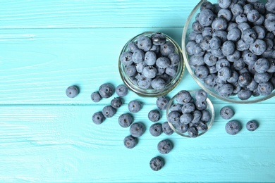 Flat lay composition with juicy blueberries and space for text on wooden table