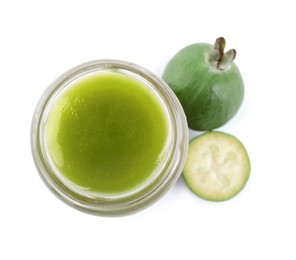Feijoa jam in glass jar and fruits on white background, top view