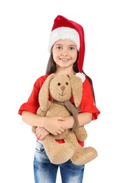 Photo of Cute little child in Santa hat with toy rabbit on white background. Christmas celebration