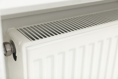 Photo of Closeup view of modern radiator. Central heating system