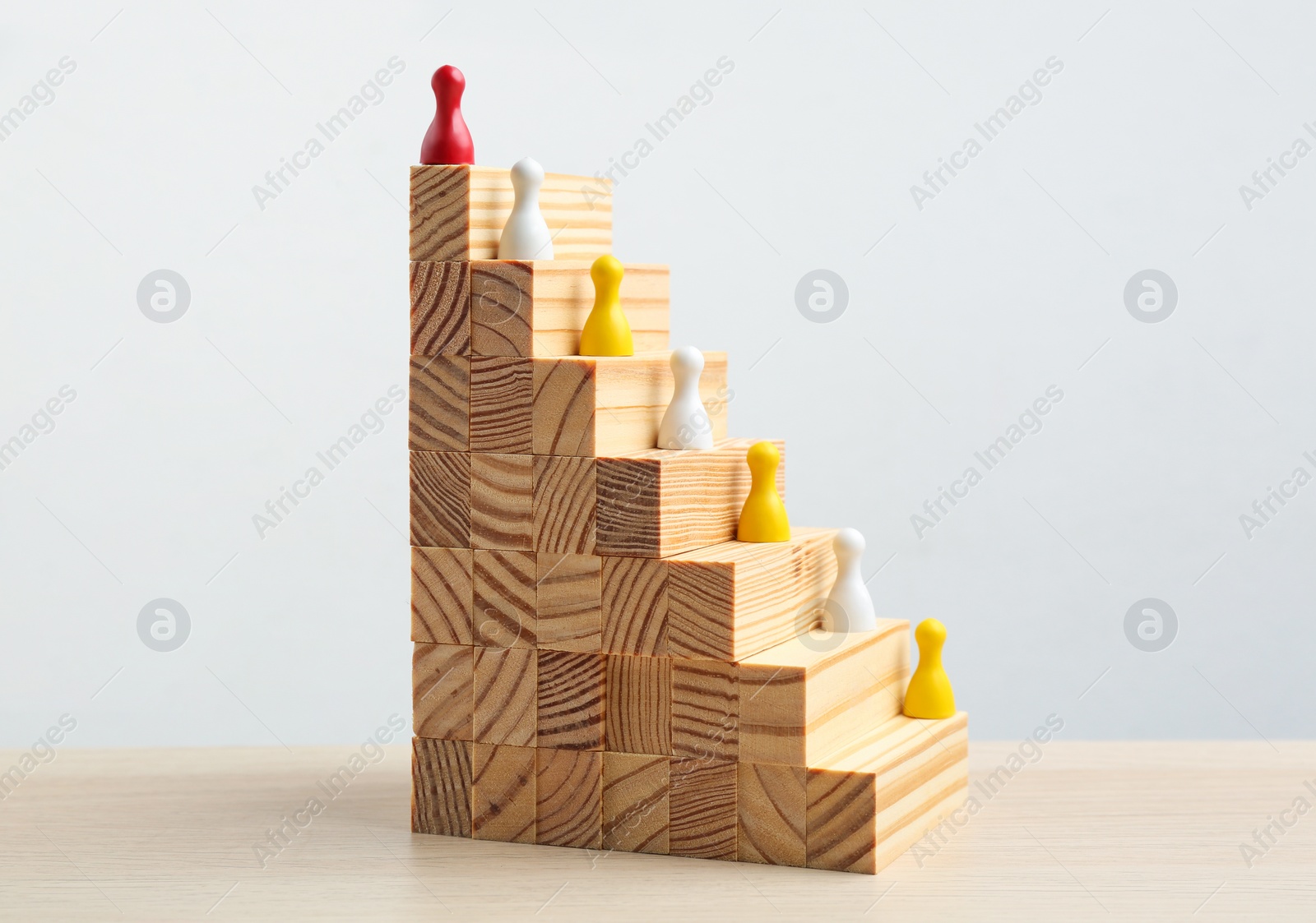 Photo of Red piece overtopping other ones on wooden stairs. Career promotion concept