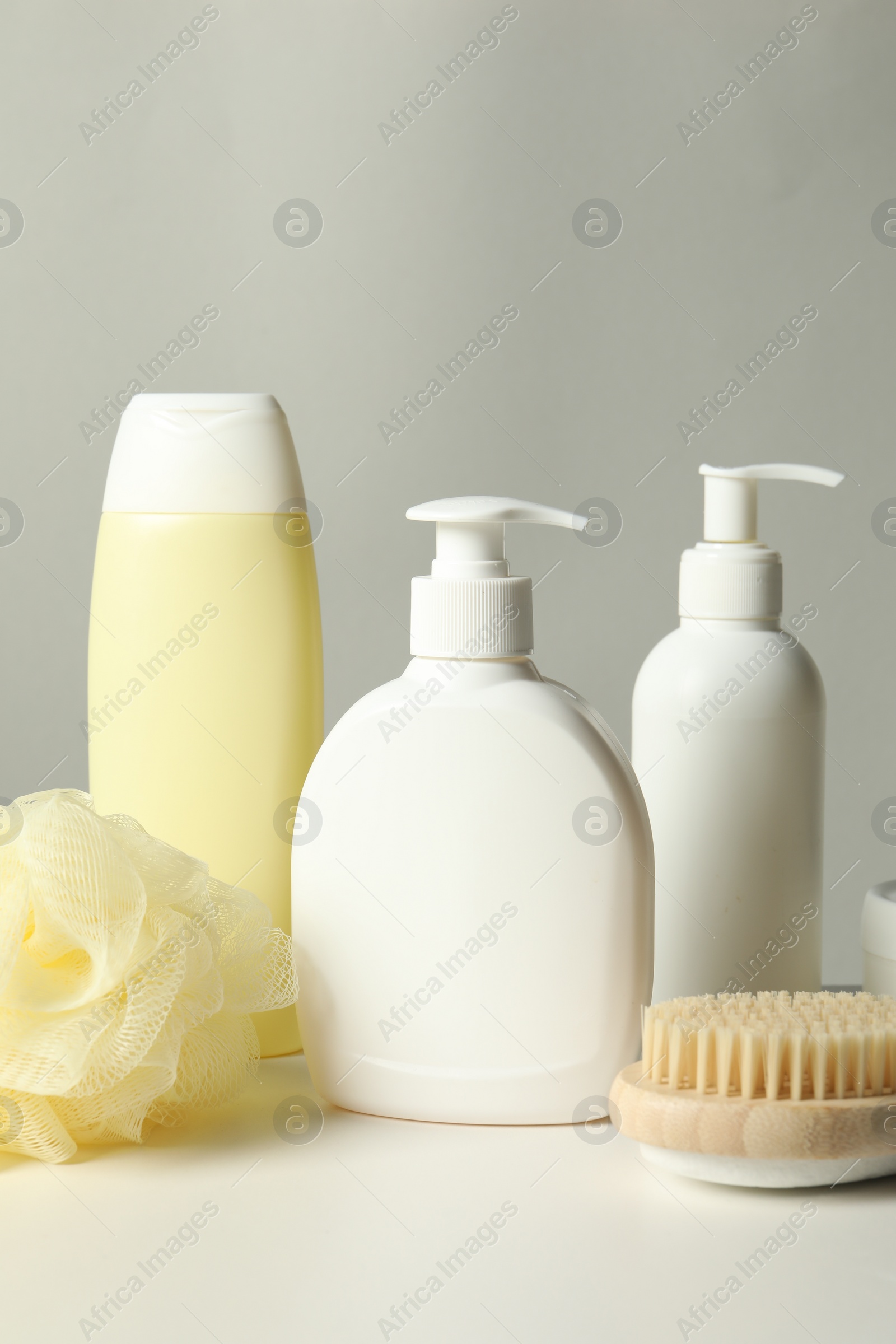 Photo of Different bath accessories on white table against grey background