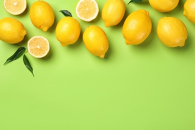 Flat lay composition with whole and sliced lemons on color background