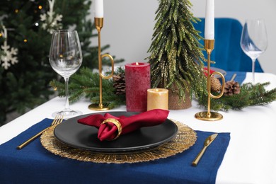 Festive place setting with beautiful dishware, cutlery and fabric napkin for Christmas dinner on white table