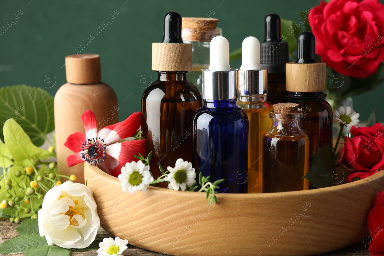 Photo of Aromatherapy. Different essential oils and flowers on table