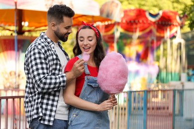 Photo of Happy couple with cotton candy at funfair