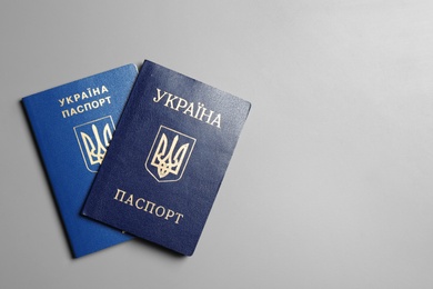 Ukrainian passports on grey background, top view with space for text. International relationships
