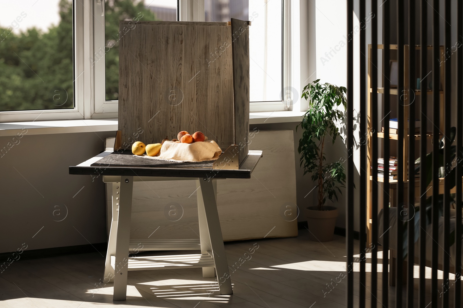 Photo of Juicy fruits and double-sided backdrops on table in photo studio