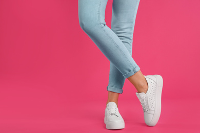 Photo of Woman wearing shoes on pink background, closeup. Space for text