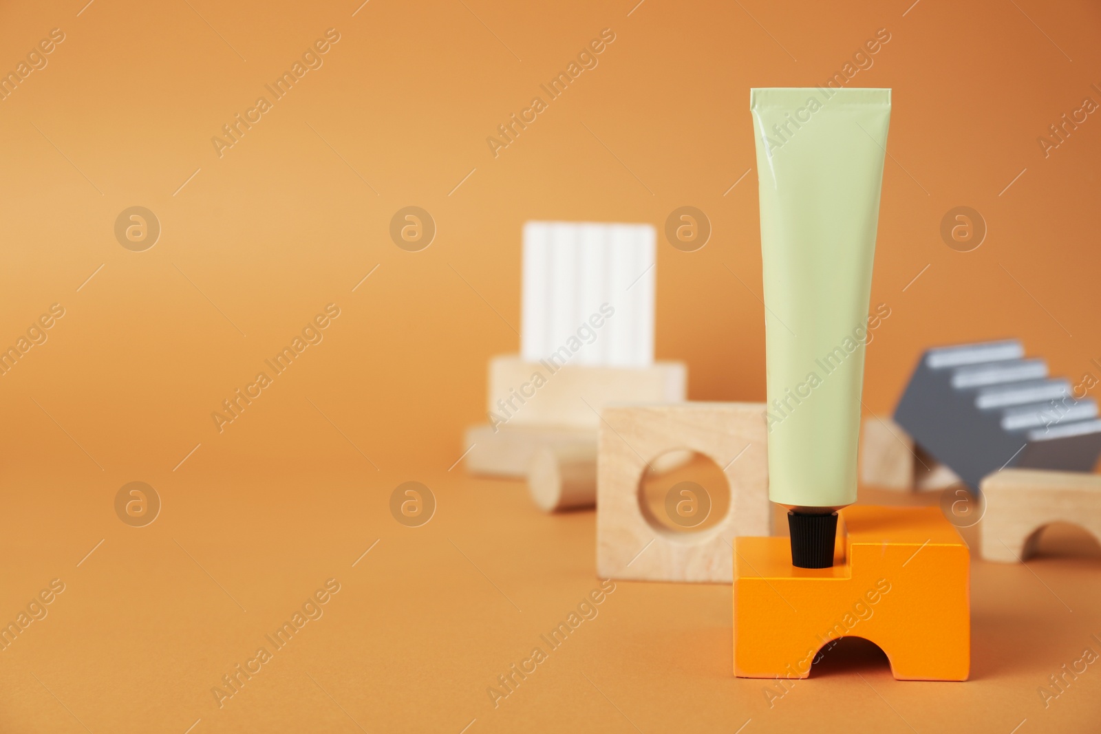 Photo of Composition with tube of hand cream on orange background, space for text