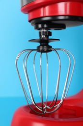 Closeup view of modern red stand mixer on turquoise background