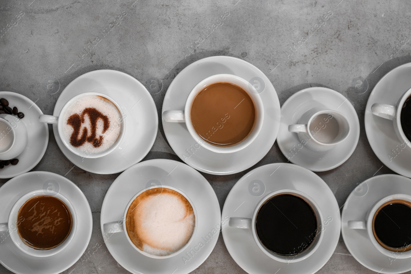 Photo of Cups of fresh aromatic coffee on grey background, top view