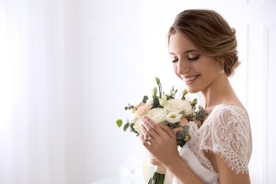 Photo of Young bride with beautiful wedding bouquet on light background. Space for text