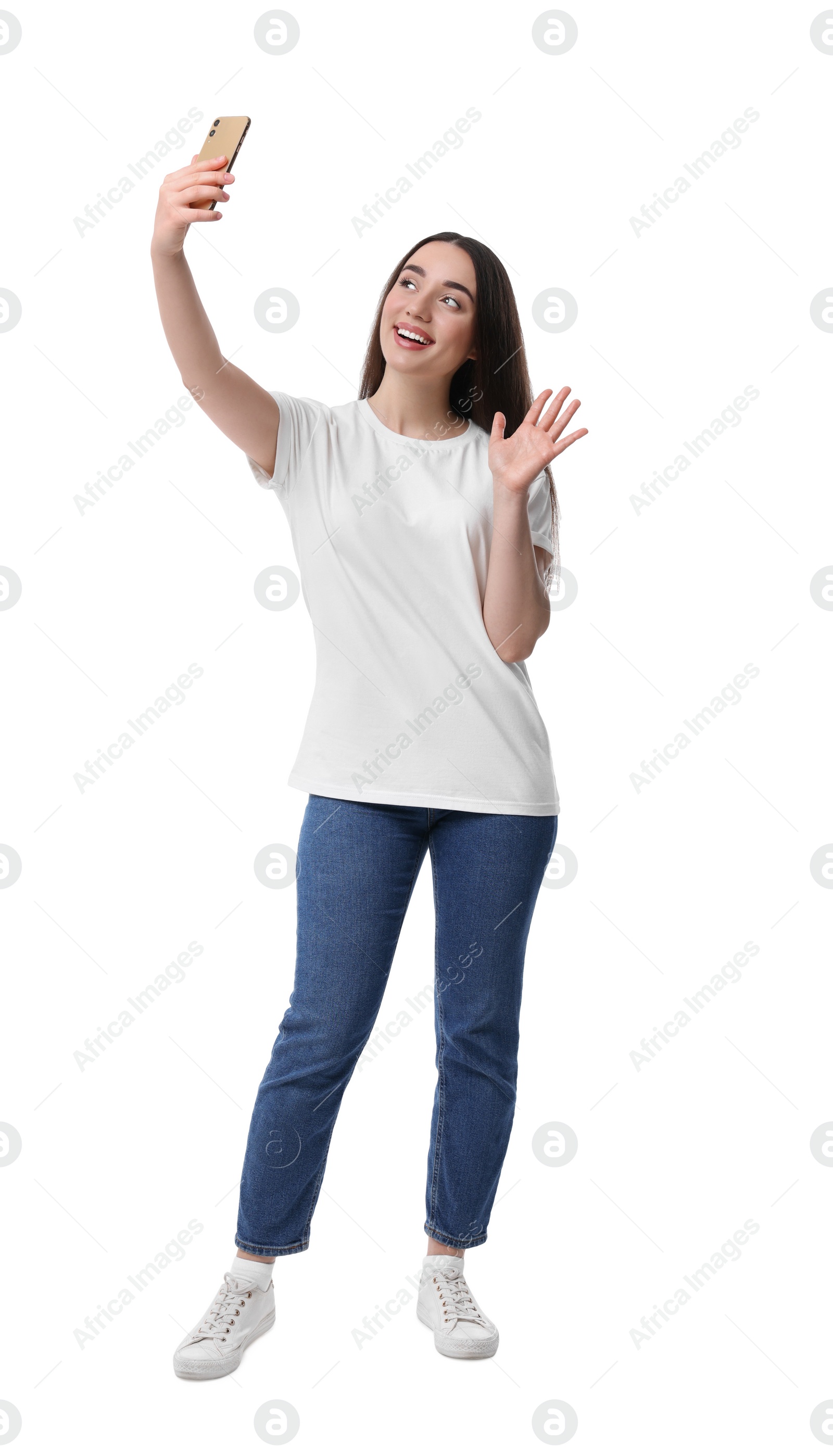 Photo of Smiling young woman taking selfie with smartphone on white background