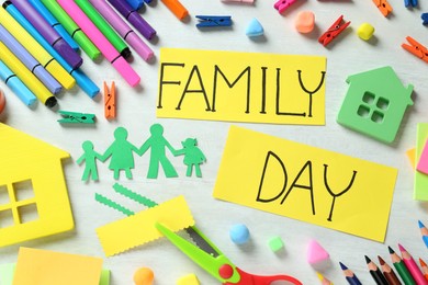 Photo of Cards with text Family Day surrounded by different stationery on white table, flat lay