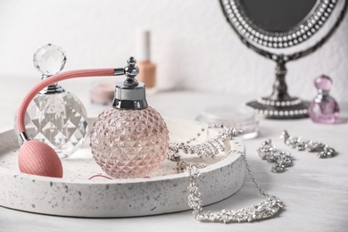 Photo of Tray with perfume bottles and jewellery on dressing table