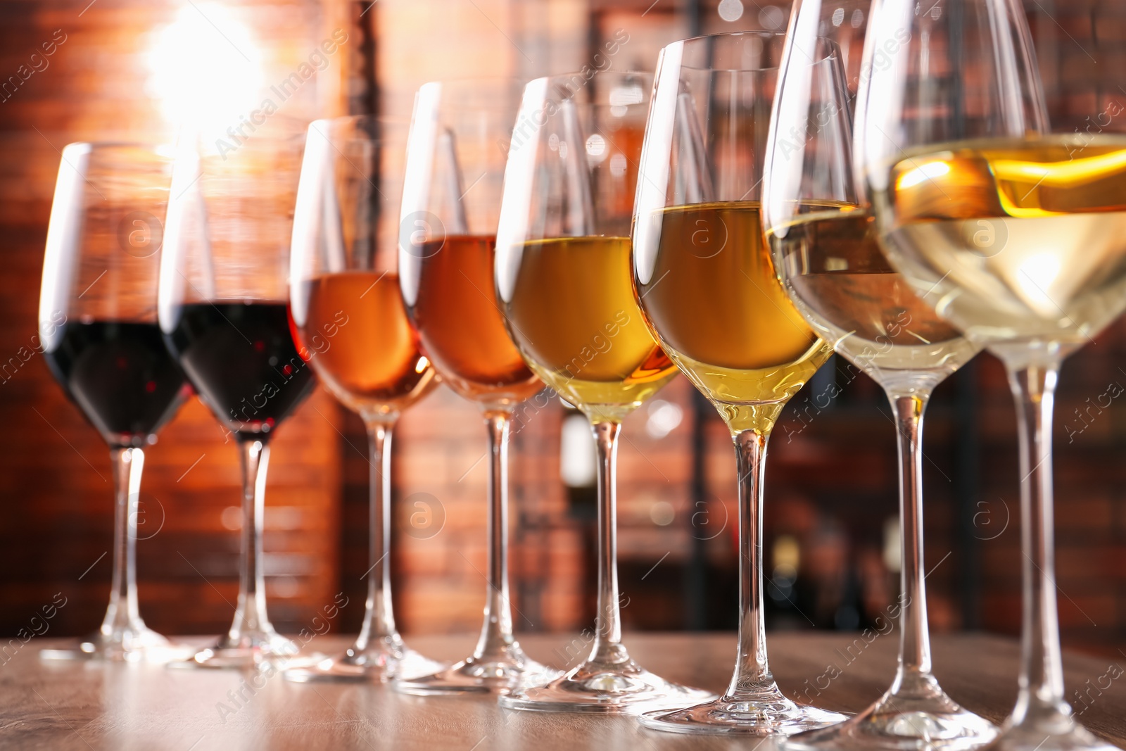 Photo of Different tasty wines in glasses on wooden table