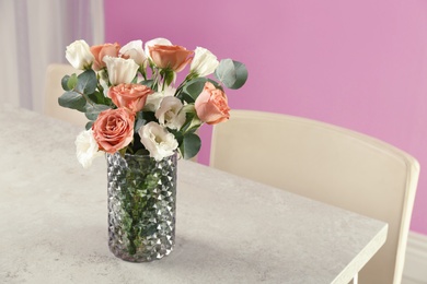 Vase with beautiful flowers as element of interior design on table in room. Space for text