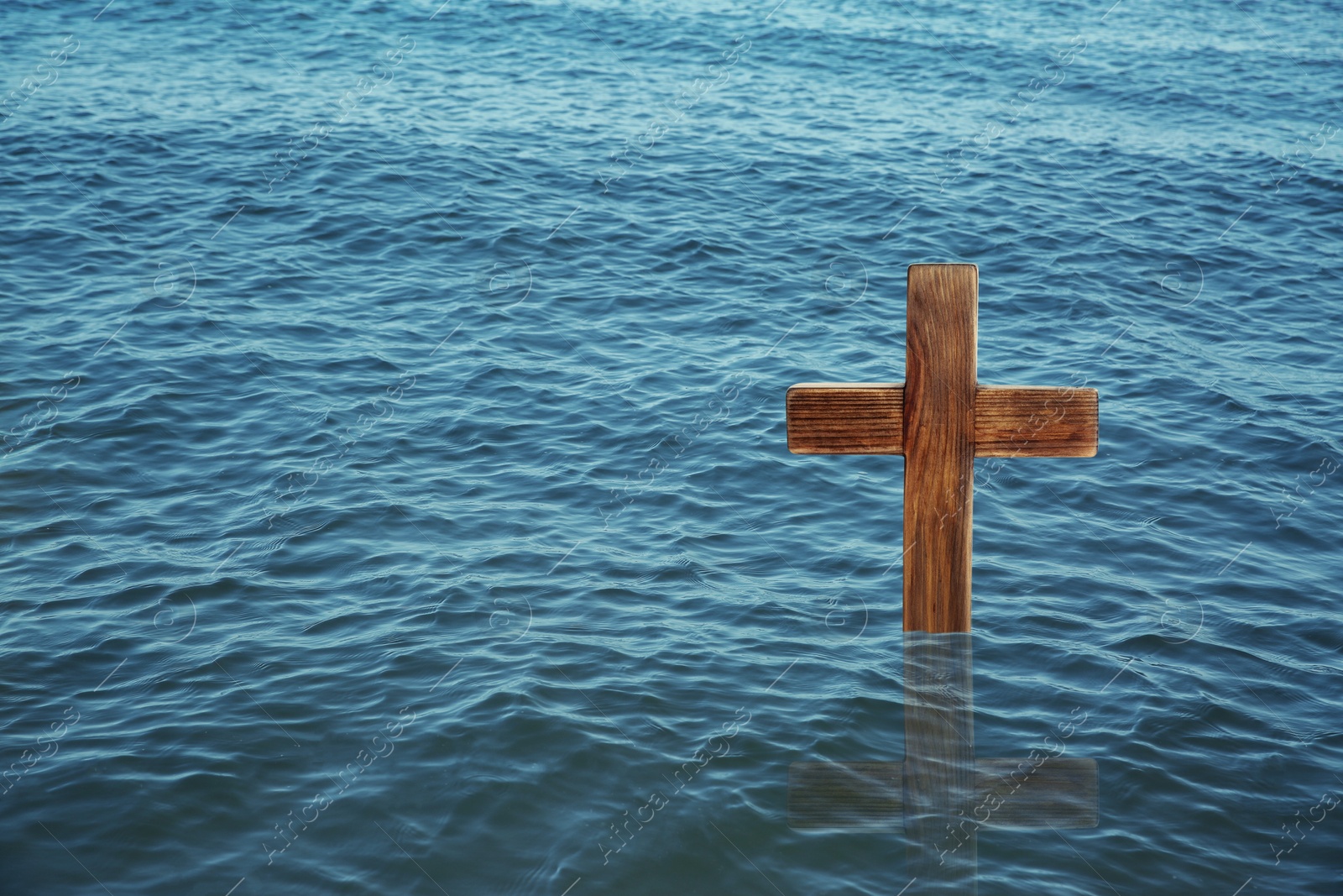 Image of Wooden cross in river for religious ritual known as baptism