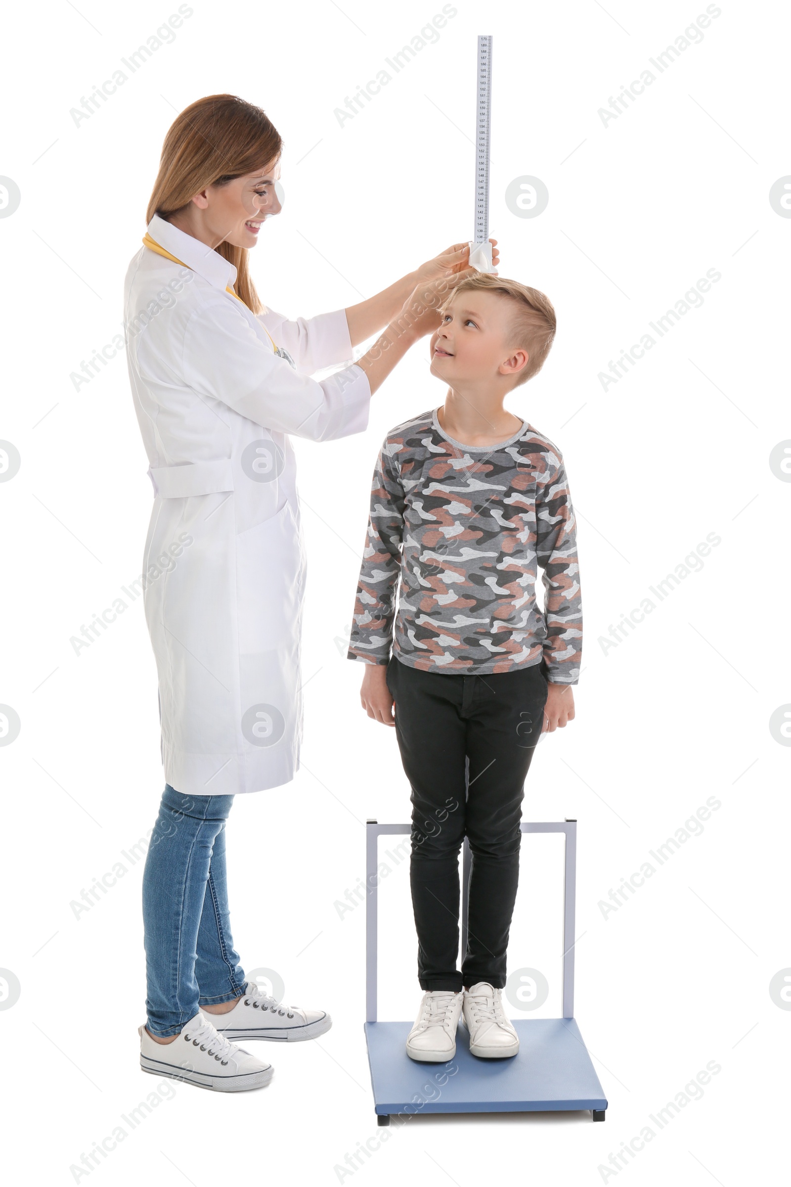 Photo of Doctor measuring little boy's height on white background