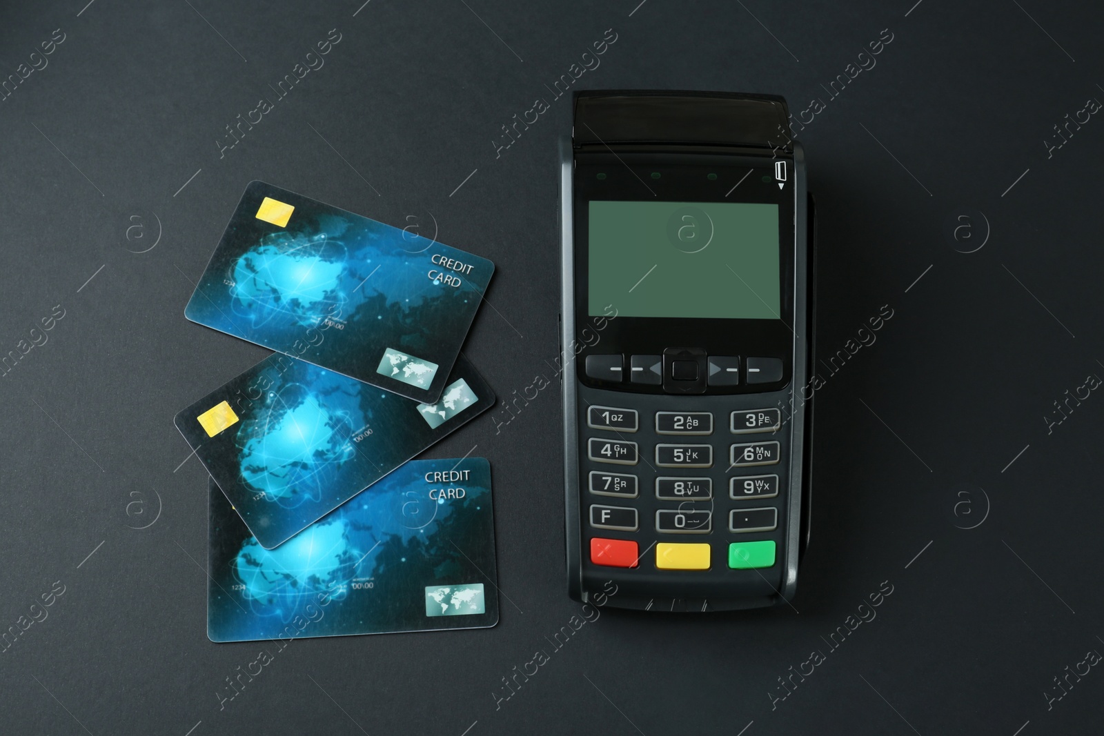 Photo of New modern payment terminal and credit cards on black background, flat lay