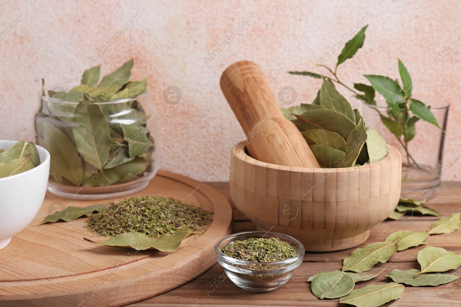 Photo of Whole and ground aromatic bay leaves on wooden table