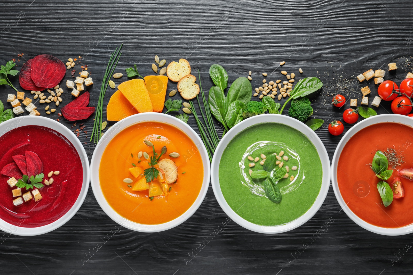 Photo of Flat lay composition with various soups and ingredients on wooden background. Healthy food