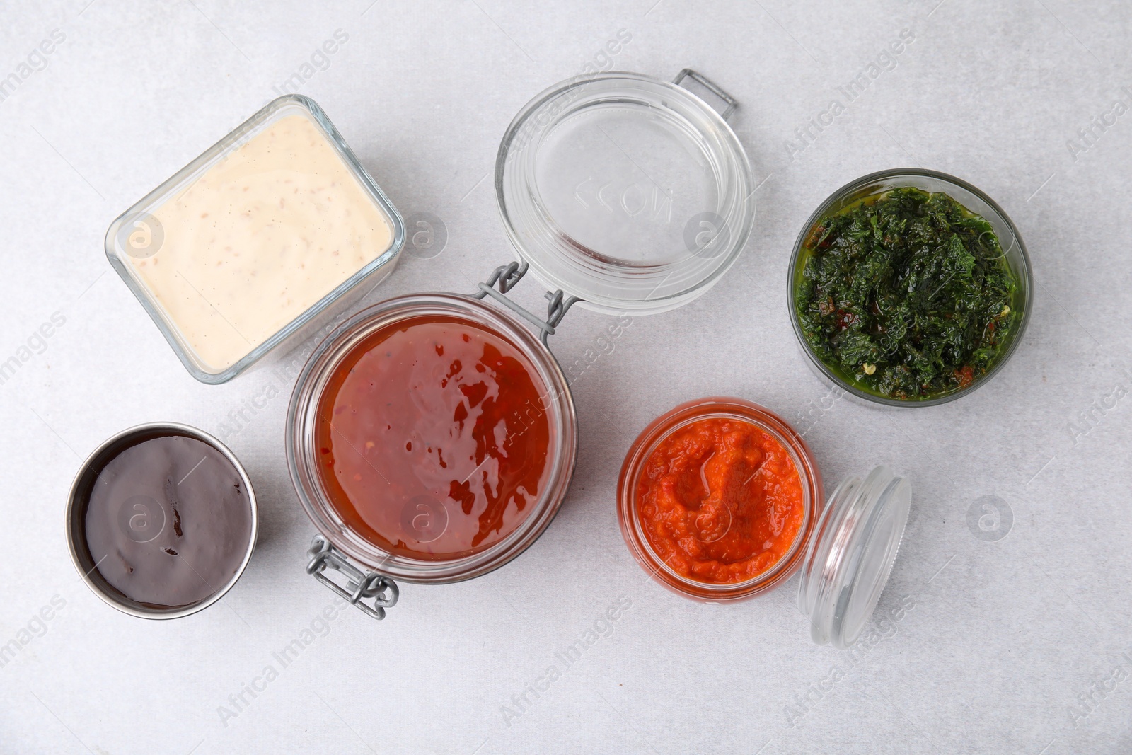 Photo of Different marinades on light table, flat lay