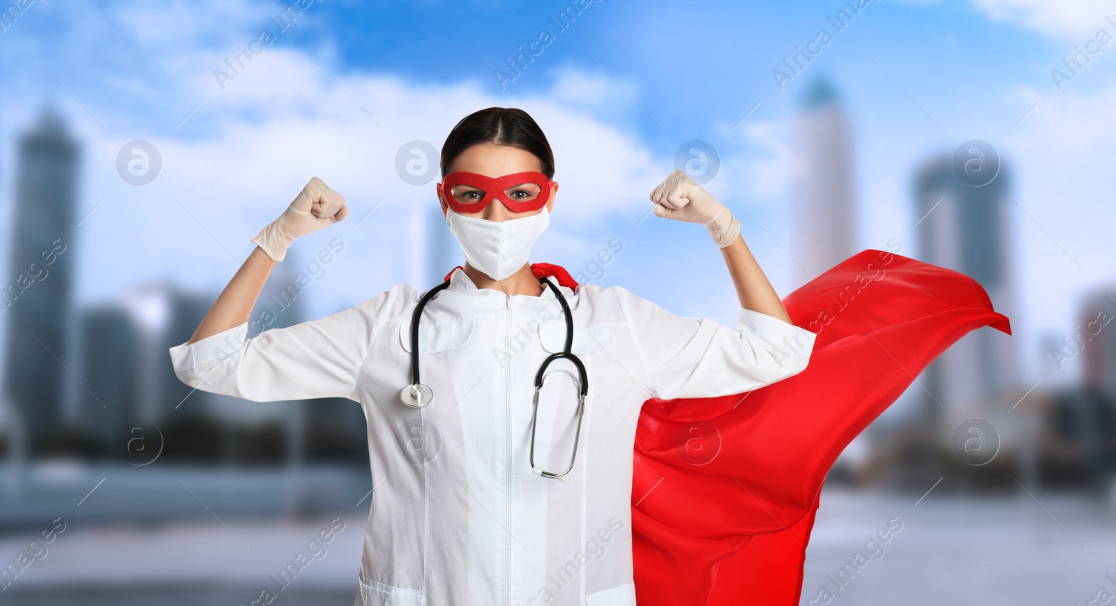 Image of Doctor dressed as superhero on city background. Medical workers fighting with dangerous diseases