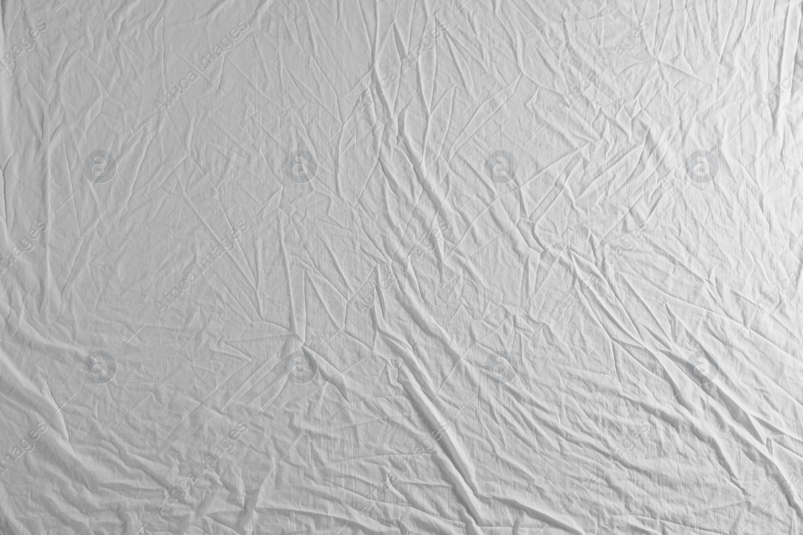 Photo of Crumpled white fabric as background, top view