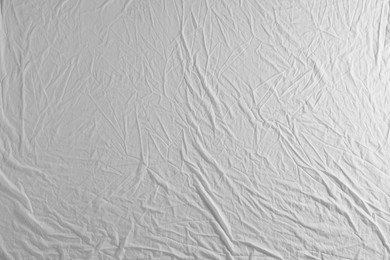 Photo of Crumpled white fabric as background, top view