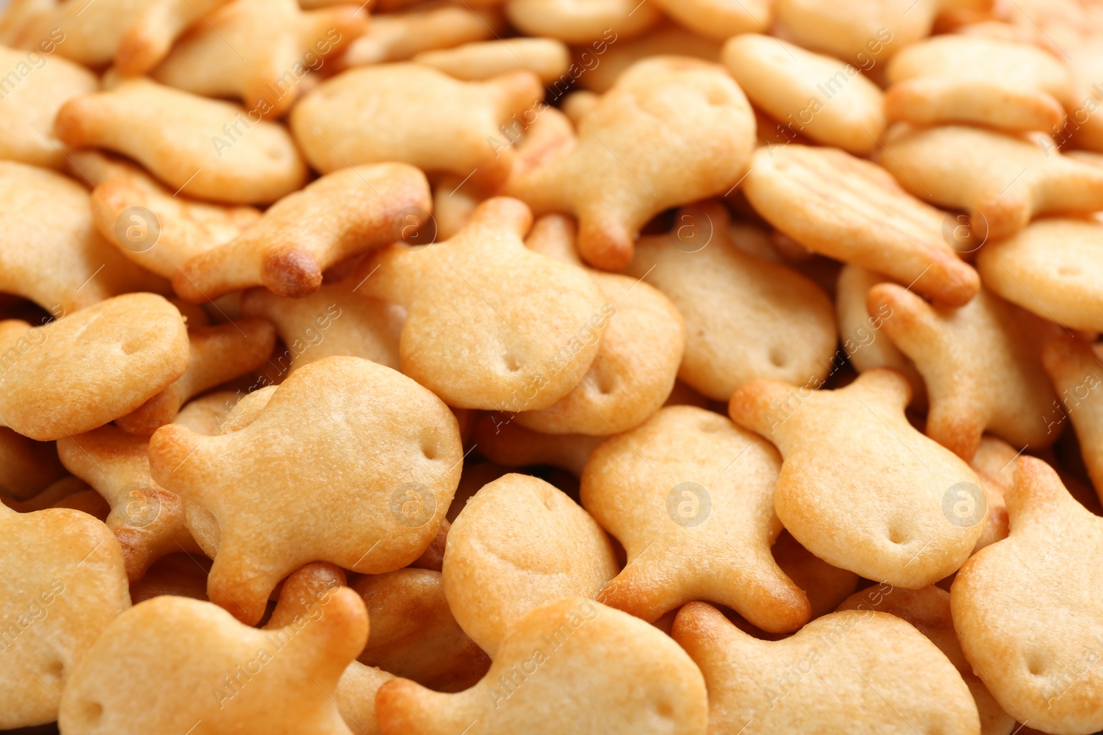 Photo of Delicious goldfish crackers as background, closeup view