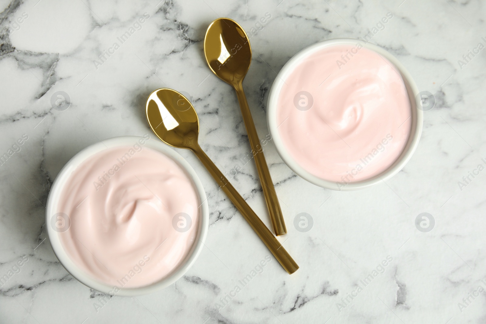 Photo of Tasty organic yogurt on white marble table, flat lay