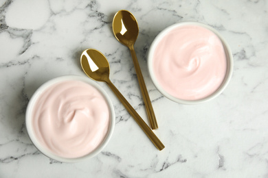 Tasty organic yogurt on white marble table, flat lay