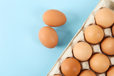 Raw chicken eggs on light blue background, flat lay