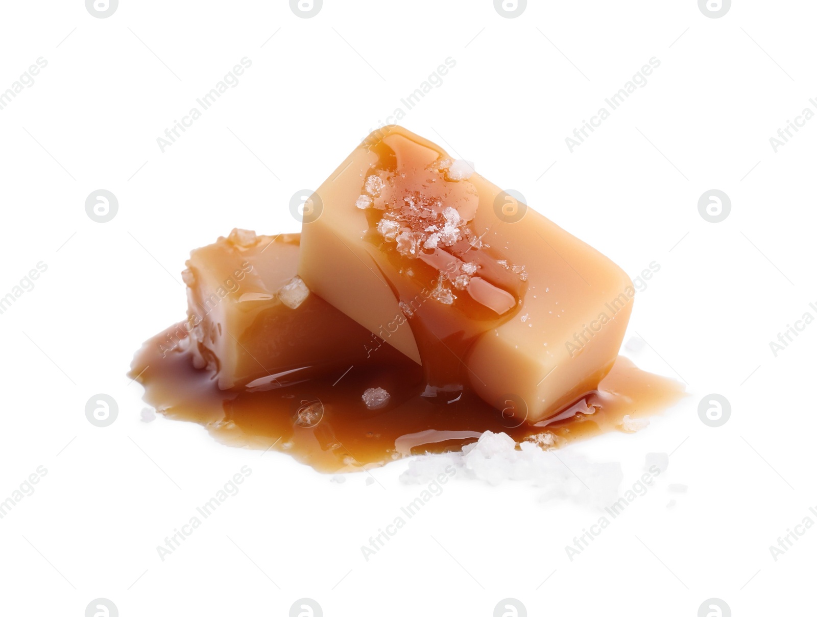 Photo of Yummy caramel candies and sea salt isolated on white