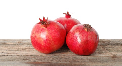 Photo of Fresh pomegranates on wooden table against white background