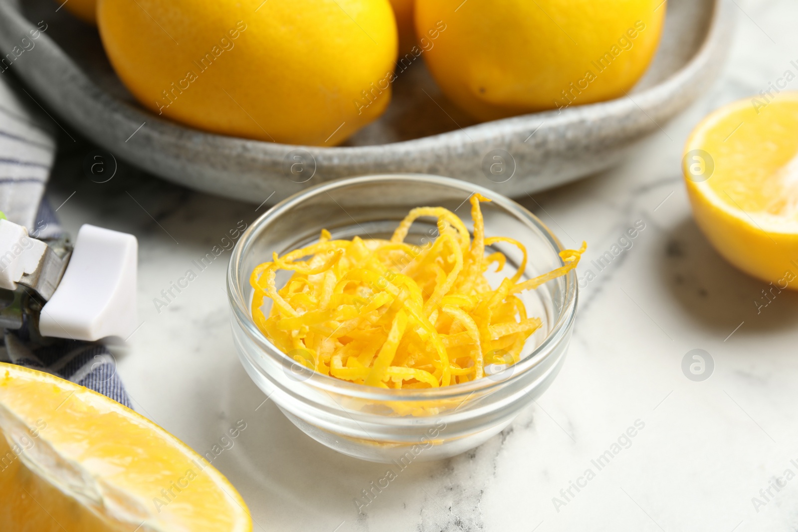 Photo of Lemon zest and fresh fruits on white marble table