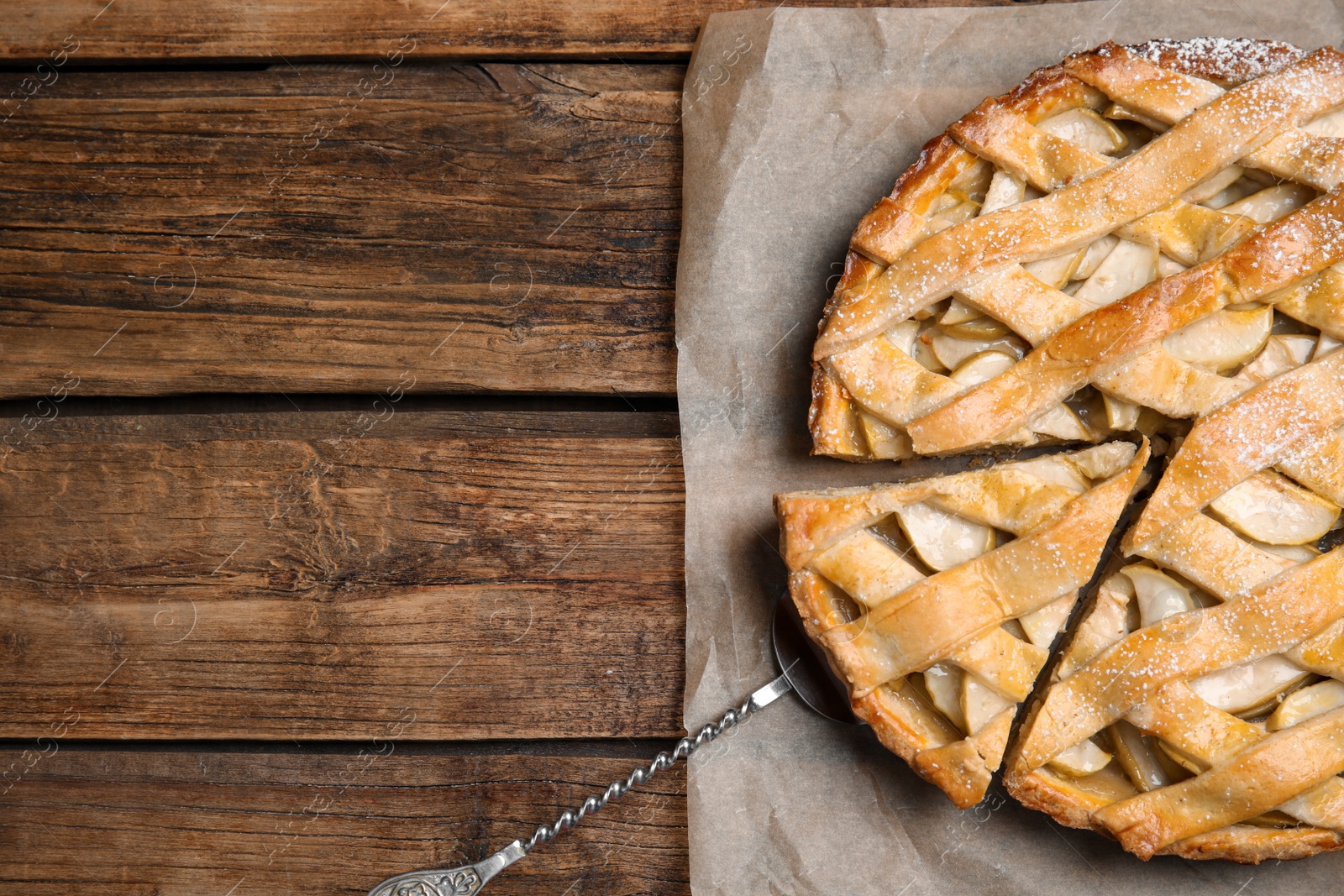 Photo of Delicious traditional apple pie on wooden table, top view. Space for text
