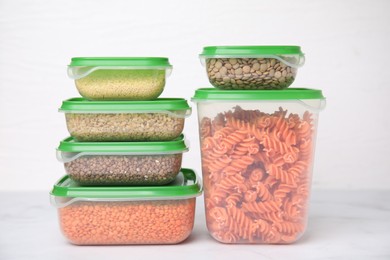 Plastic containers filled with food products on white table