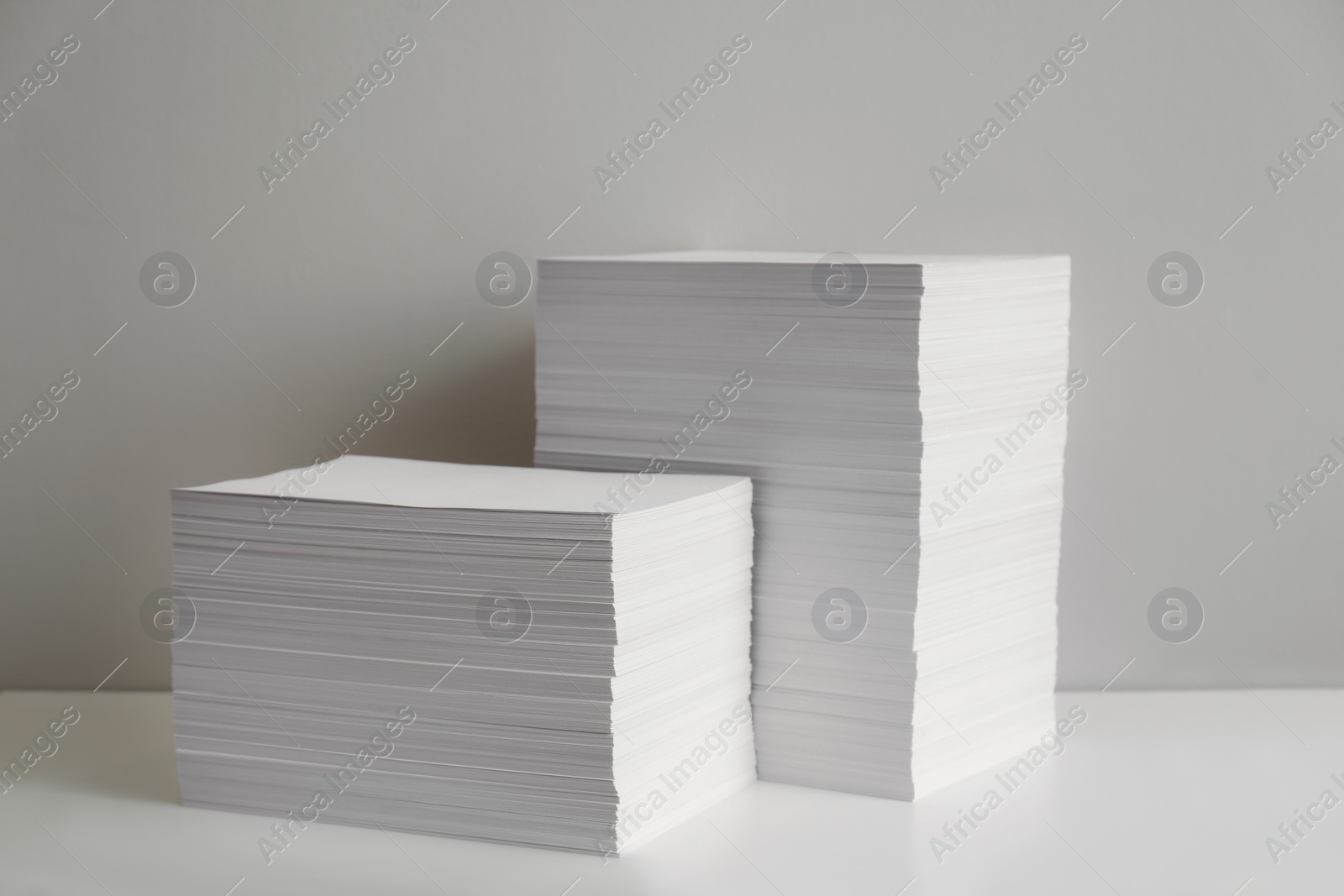 Photo of Stacks of paper sheets on white table