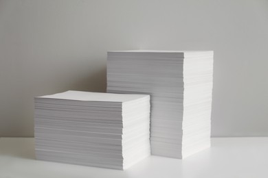 Photo of Stacks of paper sheets on white table