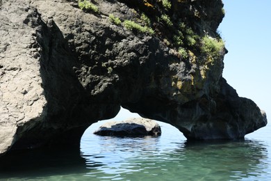 Photo of Picturesque view of natural stone arch above sea. Rock formation