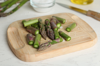 Photo of Fresh raw asparagus on white table, closeup