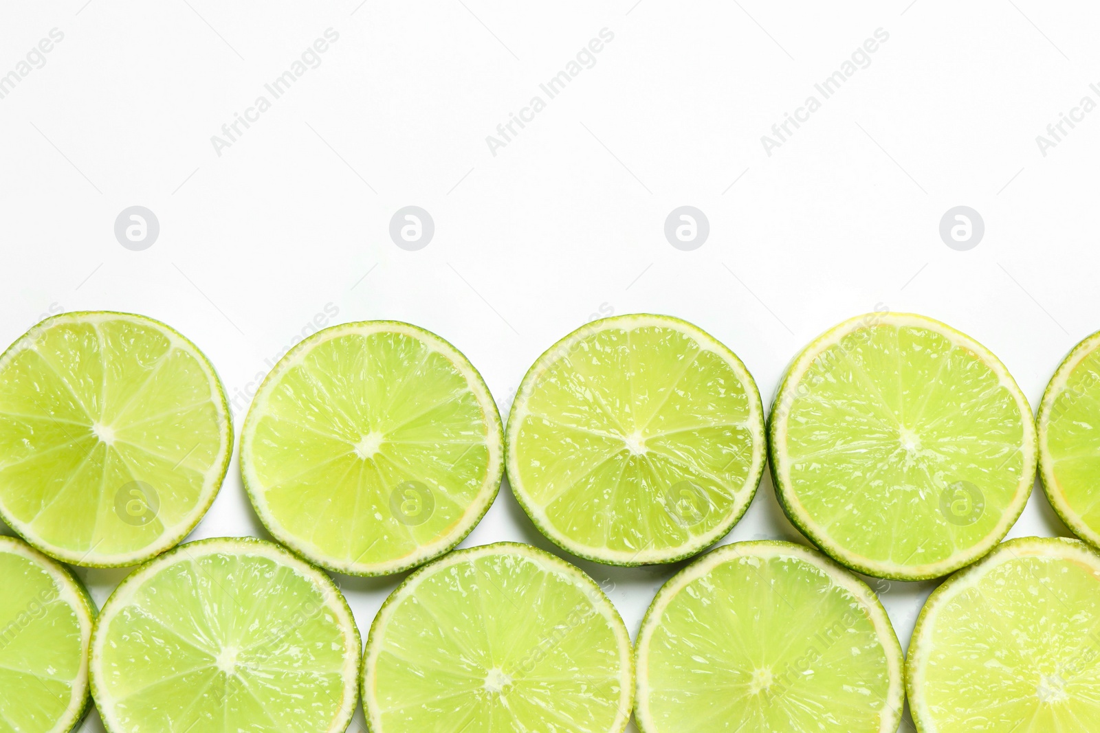 Photo of Fresh juicy lime slices on white background, flat lay. Space for text