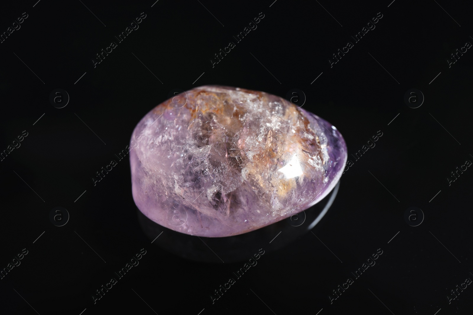 Photo of Beautiful light purple ametryn gemstone on black background